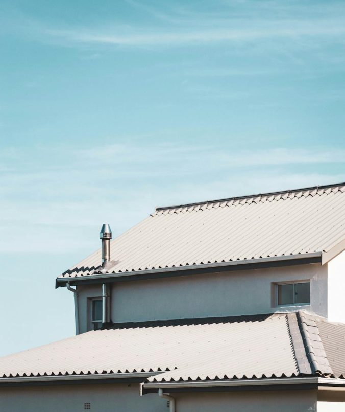 A contemporary house rooftop under a clear blue sky, showcasing architectural design.